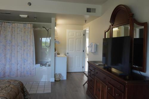 a bedroom with a dresser and a television and a bathroom at River Place Condos #410 3BD in Pigeon Forge