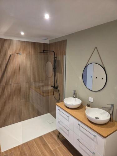 a bathroom with two sinks and a shower and a mirror at Les embruns du retz in Chaumes en Retz