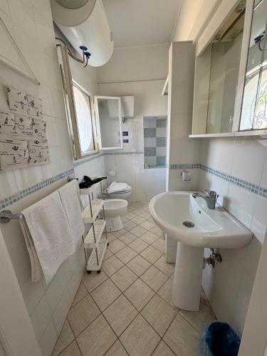 a white bathroom with a sink and a toilet at Casa vacanze Piedigrotta in Pizzo