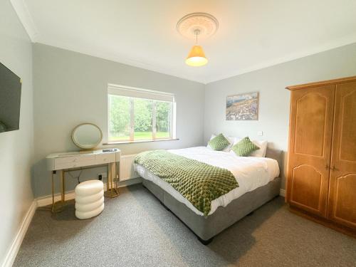 a bedroom with a bed and a desk and a window at Ivy Guesthouse in Kilkenny