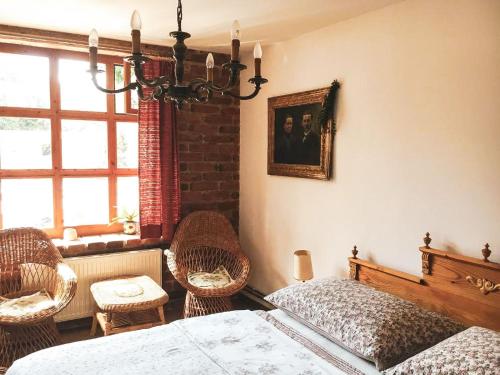 a bedroom with a bed and chairs and a window at Penzion Prezident in Soběraz