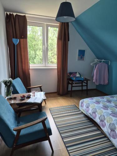 a bedroom with a bed and a chair and a table at Rodzinny dom w Rożnowie Duży Ogród i Zabawki in Rożnów