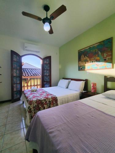 a hotel room with two beds and a ceiling fan at Pousada Alecrim Dourado in Paraty