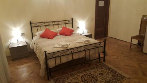 um quarto com uma cama grande e 2 almofadas vermelhas em Garden Suite em Génova