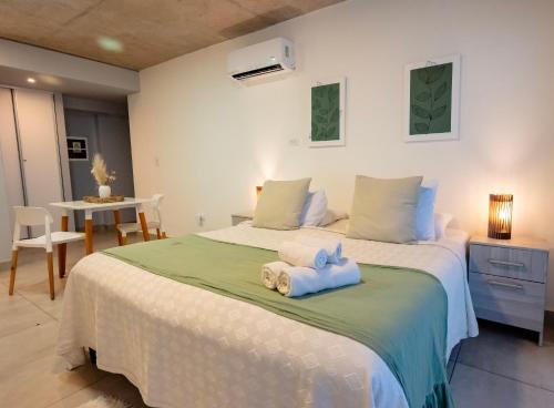 a bedroom with a large bed with towels on it at Cómodo departamento centro de Salta by BEDBOOK in Salta