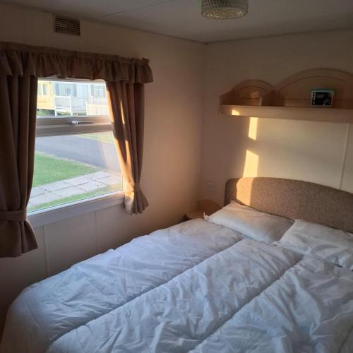 a bed in a bedroom with a window at Atlas Florida in Ingoldmells