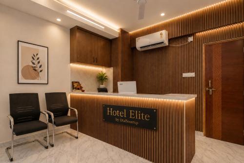 a hotel lobby with a hotel elite sign and two chairs at Hotel Elite kukatpally Near Nexus Mall in Hyderabad