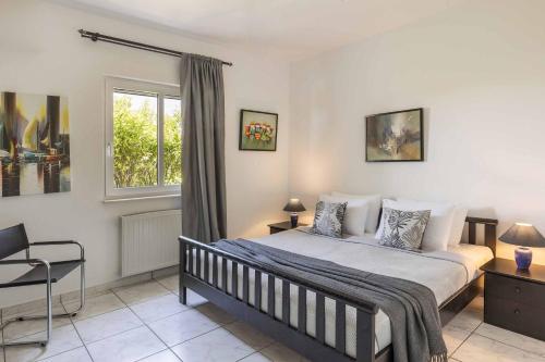a bedroom with a bed and a window at Villa Polymnia in Kaligata
