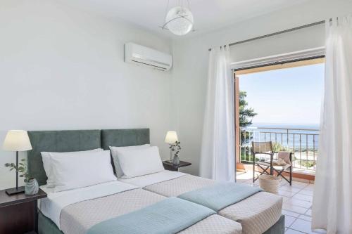a bedroom with a bed with a view of the ocean at Villa Agnandi in Lakíthra