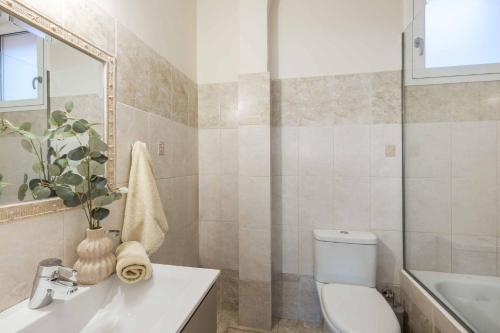 a bathroom with a toilet and a sink and a mirror at Villa Agnandi in Lakíthra