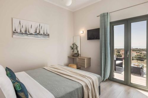 a white bedroom with a bed and a balcony at Casa Bella in Karavádhos