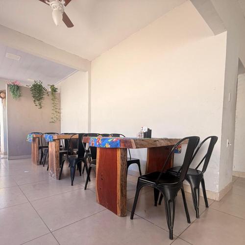 a room with wooden tables and chairs and a ceiling at Hotel Coutinho in Pirapora