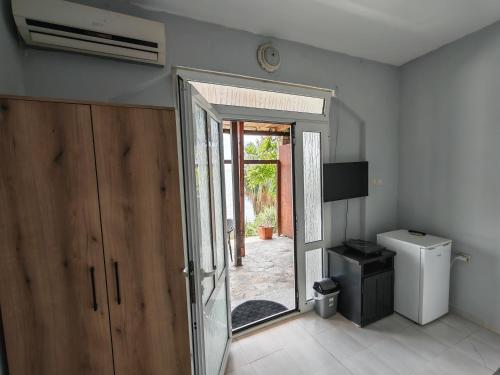 a bathroom with a door open to a yard at Lana Seafront Apartments in Šušanj