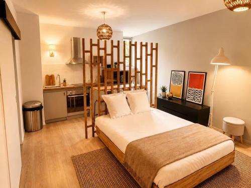 a bedroom with a large bed and a kitchen at LE PANCAUT- Chaleureux - Hyper Centre in Mont-de-Marsan