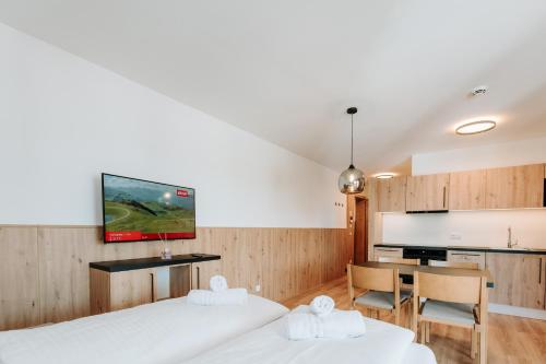 two beds in a room with a table and a kitchen at KitzSki Living in Kitzbühel
