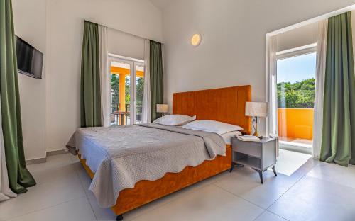 a bedroom with a bed and a large window at Lotus Villas Resort in Pula
