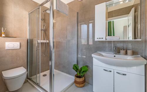 a bathroom with a shower and a sink and a toilet at Lotus Villas Resort in Pula