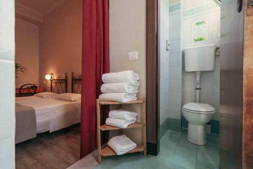 a bathroom with a bed and a toilet and towels at Hotel Italia in Turin