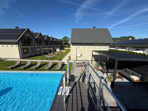 an image of a house with a swimming pool at Domki Gala- blisko plaży, basen z podgrzewaną wodą , sauna , parking in Grzybowo