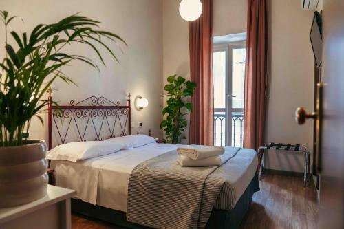 a bedroom with a bed and a plant and a window at Hotel Italia in Turin