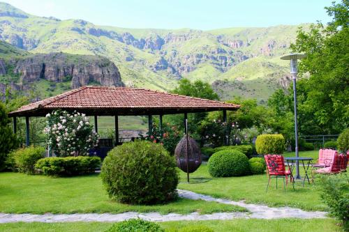 a gazebo in a garden with mountains in the background at Vardzia Resort in Vardzia