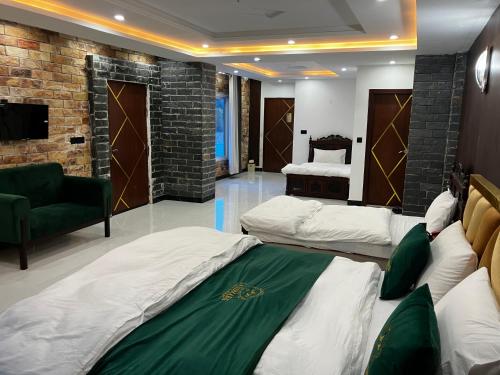 a hotel room with two beds and a couch at Landmark Hotel & Resort in Taiwāl