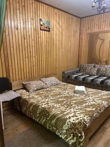 a bedroom with a bed and a wooden wall at U Bogdana in Yaremche