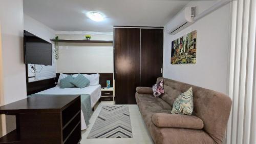 a living room with a couch and a bed at Baviera Studio Canela in Canela