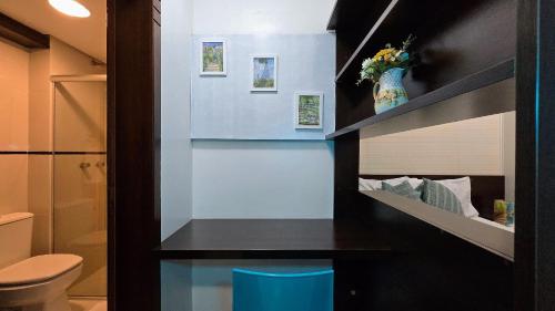 a bathroom with a toilet and a blue stool at Baviera Studio Canela in Canela