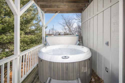 a jacuzzi tub on a porch with a window at Flat Top Lodge in Blowing Rock