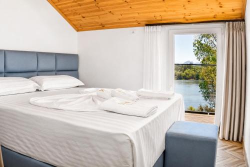 a bedroom with a large bed with a window at Villa Osmani in Shkodër