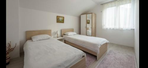 a bedroom with two beds and a window at Vila-kuca"Jasmin"pored rijeke i jezera in Konjic