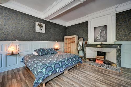 a bedroom with a bed and a fireplace at lemasrocamour in Roquemaure