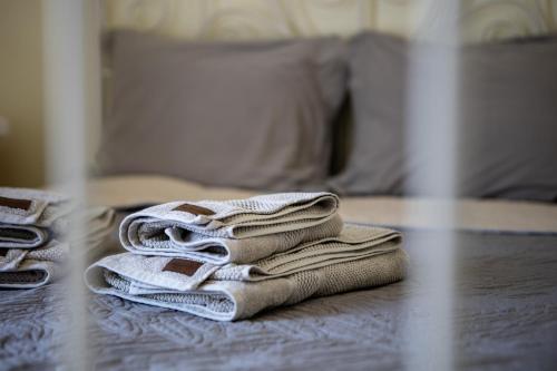 a pile of towels sitting on top of a bed at Emotion Apartments in Asprovalta
