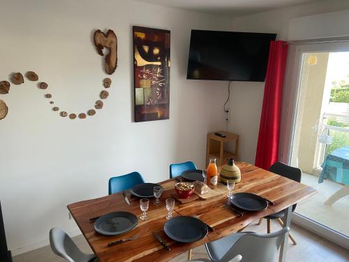 a dining room with a wooden table and chairs at L'escale marine in Pléneuf-Val-André