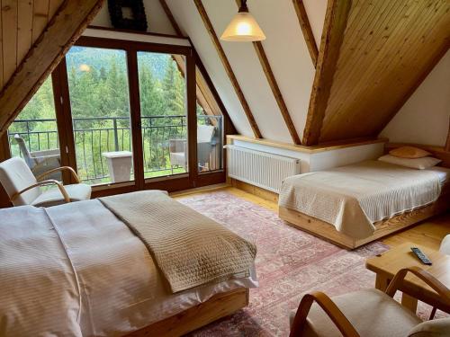 a bedroom with two beds and a large window at Willa Sosna in Kościelisko