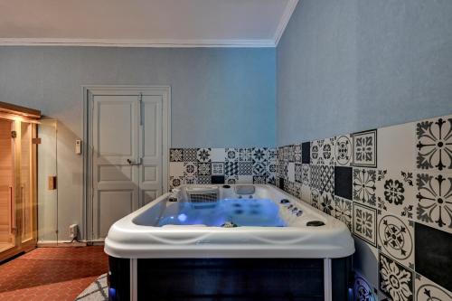 a bath tub in a bathroom with blue and white tiles at lemasrocamour in Roquemaure