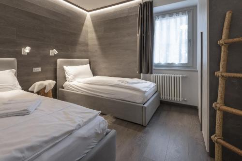 a room with two beds and a window at Angels Home 3-AffittiPontediLegno in Ponte di Legno