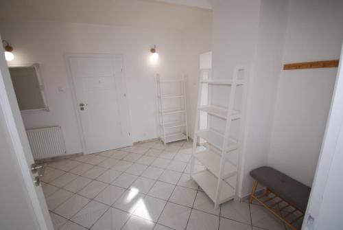 an empty room with white shelves and a door at Noclegi Dywity Barczewskiego 27 in Dywity