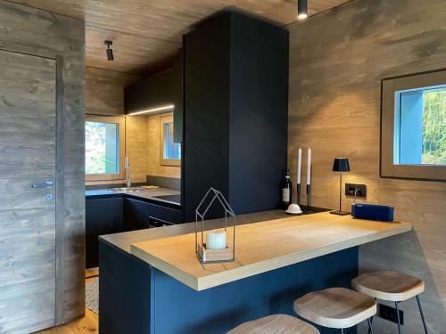 a kitchen with blue cabinets and two stools at Chalet Baita Aria - AffittiPontediLegno in Ponte di Legno