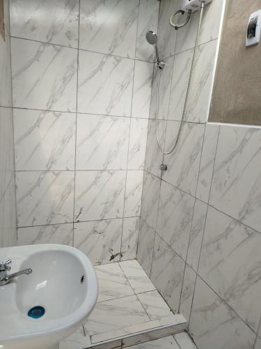 a white bathroom with a shower and a sink at Los Laureles Sacred valley in Urubamba