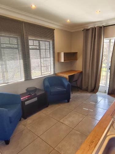 a living room with a blue chair and a table at River Suite at On-the-Up in Potchefstroom