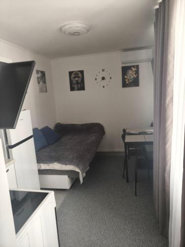 a small bedroom with a bed and a desk at Квартира- студия in Chişinău