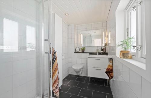 a white bathroom with a sink and a toilet at Large & Cozy Stavanger Apt in Stavanger