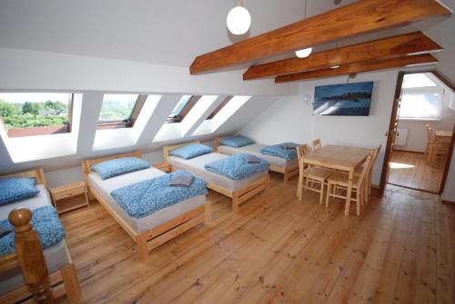 a room with two beds and a table and chairs at Noclegi Dywity Barczewskiego 27 in Dywity