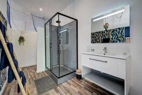 a bathroom with a glass shower and a sink at lemasrocamour in Roquemaure