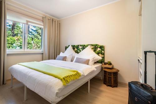 a bedroom with a large white bed with a yellow blanket at Lakeside Retreat Apartment in Bestensee