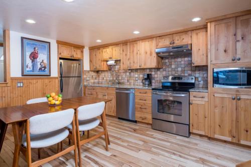 a kitchen with wooden cabinets and a wooden table and chairs at Krystal Villa #5 in Ketchum