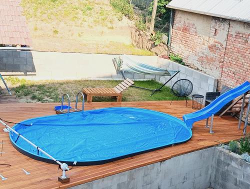 a hot tub on a deck with a table and a chair at Pokoje v přízemí RD - terasa, bazén, zahrada in Nechvalín