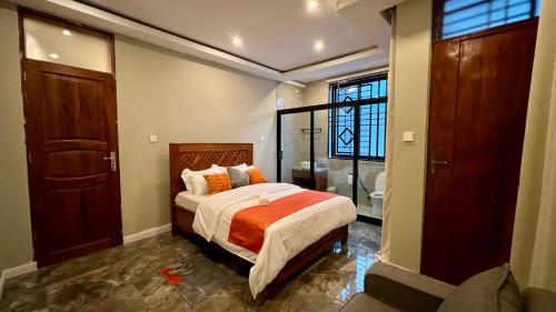 a bedroom with a large bed and a bathroom at The Yoyo's Stay in Arusha
